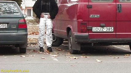 Girl peeing between the cars