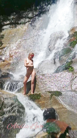 Watching on naked slim young girl taking shower in a waterfall